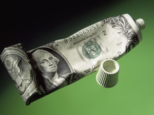 US dollar wrapped onto toothpaste tube