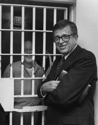 Chuck Colson visiting with a  prisoner. 