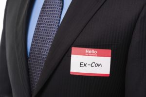 Red Hello My Name Is sticker name tag on man in suit and tie with blue shirt