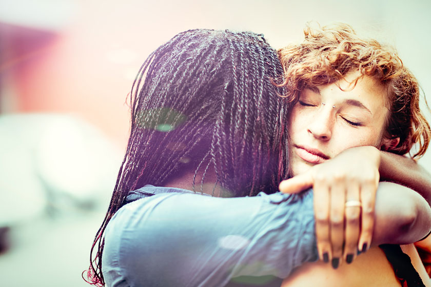 african american woman comforting caucasian woman