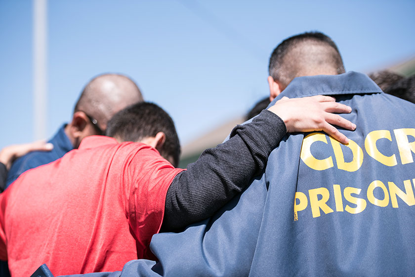 volunteer prays with prisoners