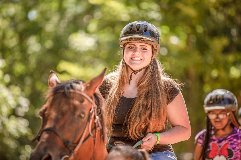 angel tree camping child rides horse at frontier camp