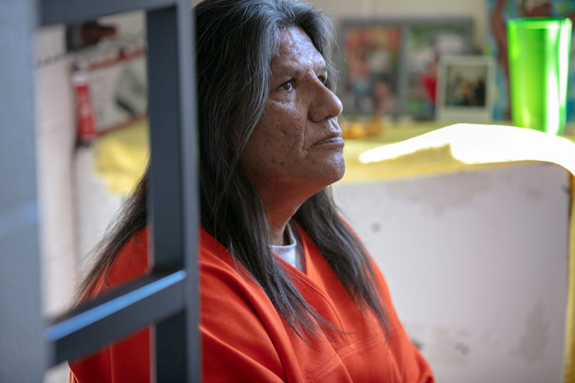 a prisoner sits alone in her cell