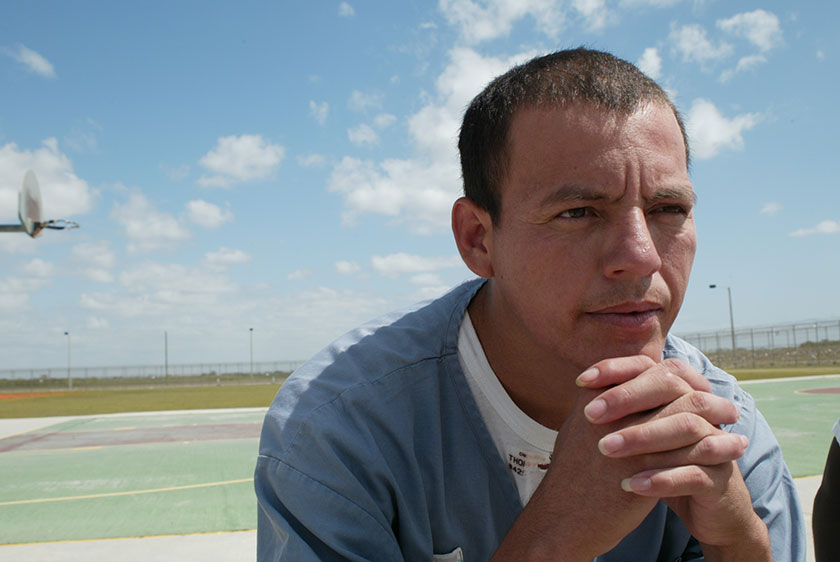 prisoner sits on prison yard