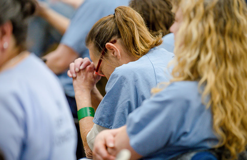 a woman prays during a hope event