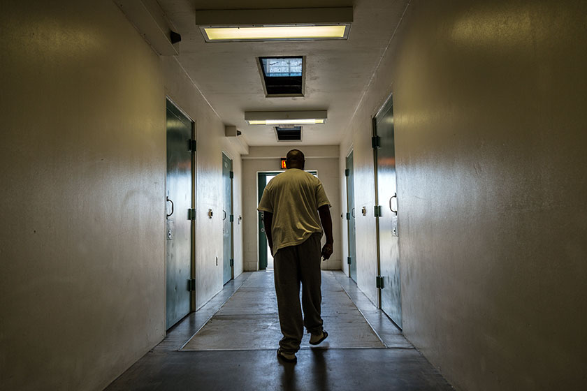 a prisoner walks down a hall at a correctional facility