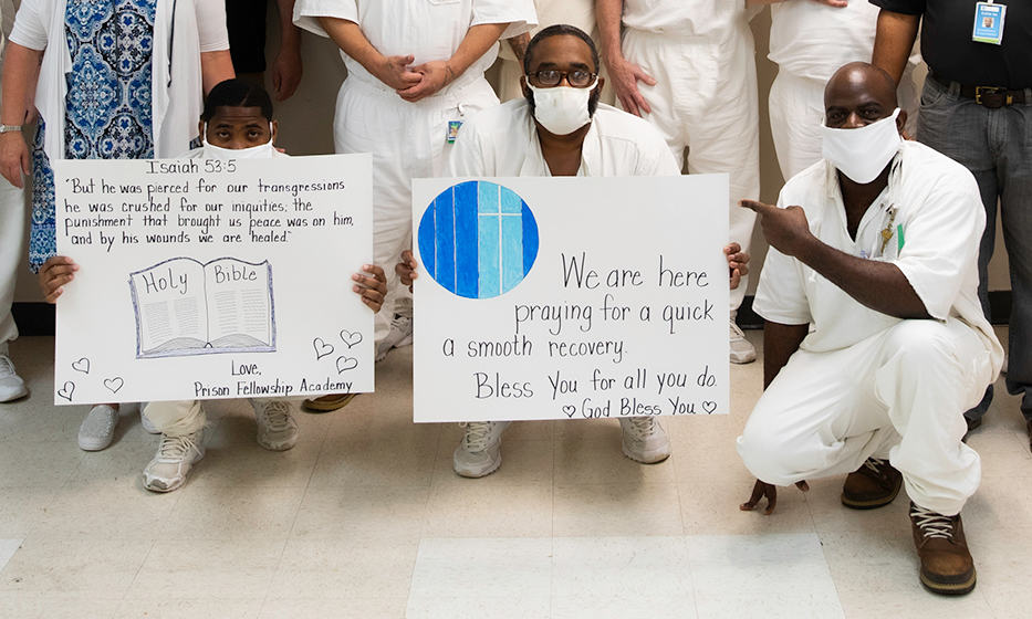prisoners hold signs in support of covid-19 patients