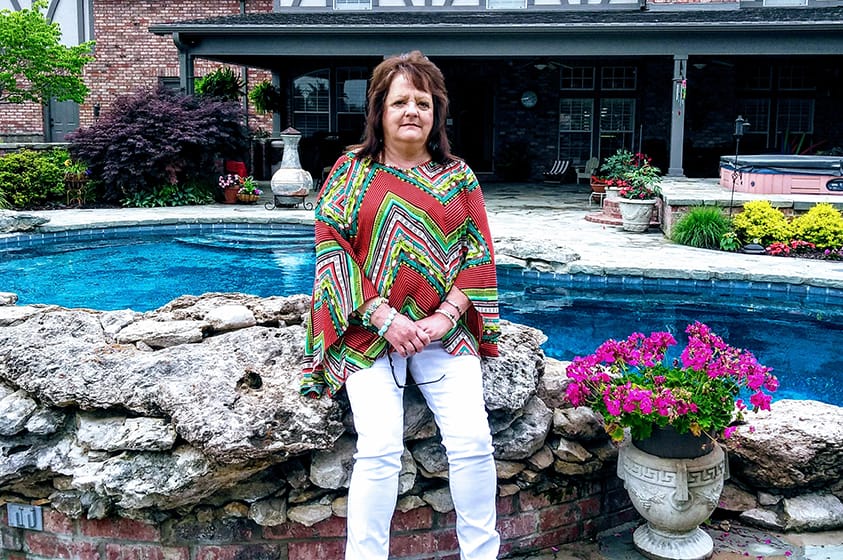 woman sits by pool