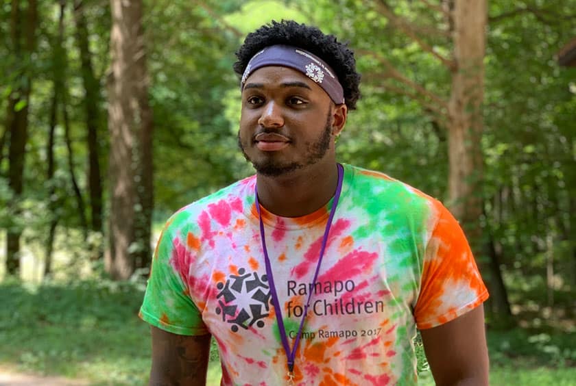 black man at summer camp wearing a tie-dye t-shirt
