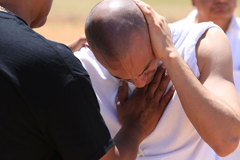 prisoner prays with volunteer